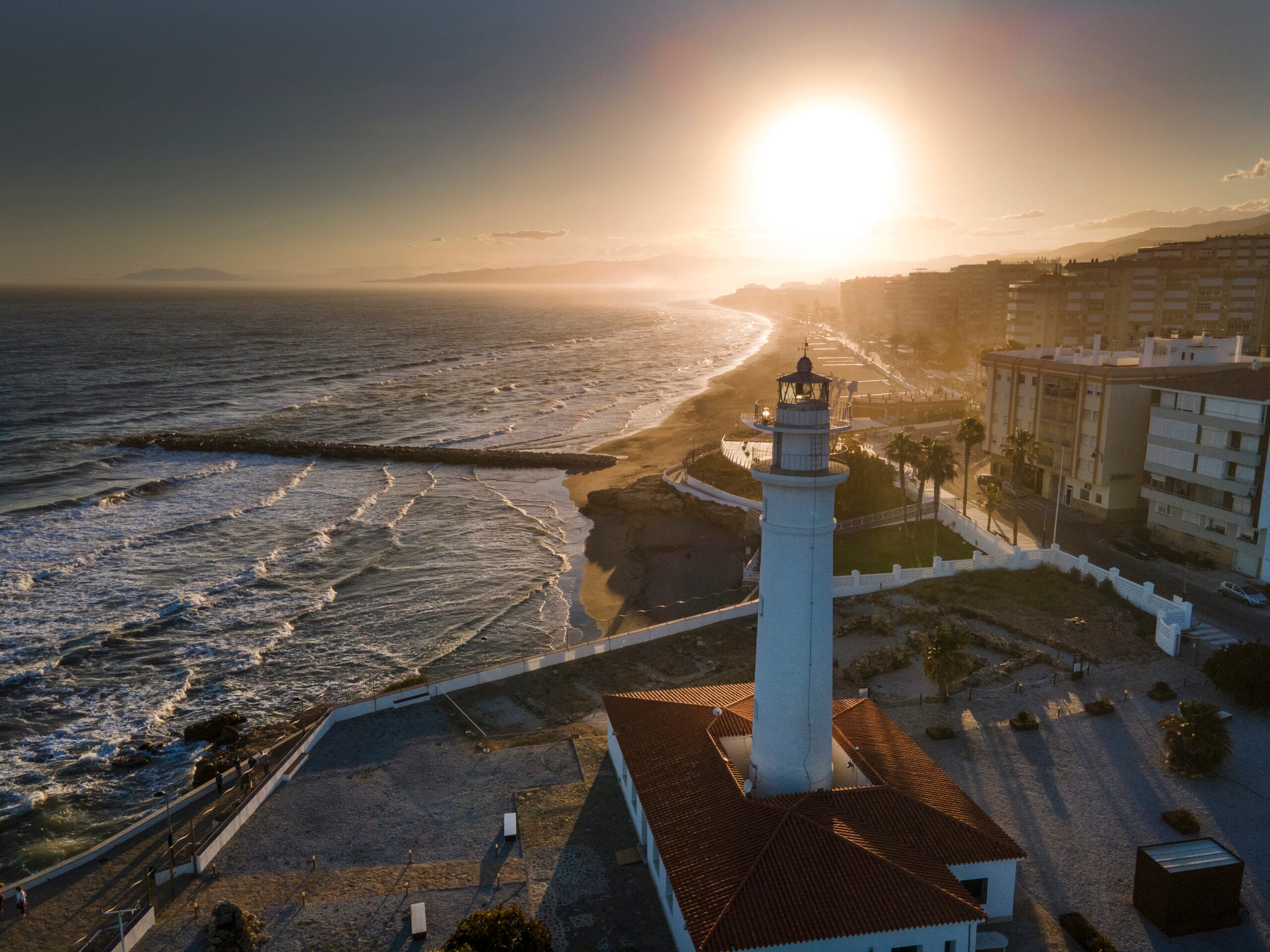 The sun sets behind the lighthouse at Torrox Costa. Photo by Jason Elliott. The sun sets behind the lighthouse at Torrox Costa. Photo by Jason Elliott.