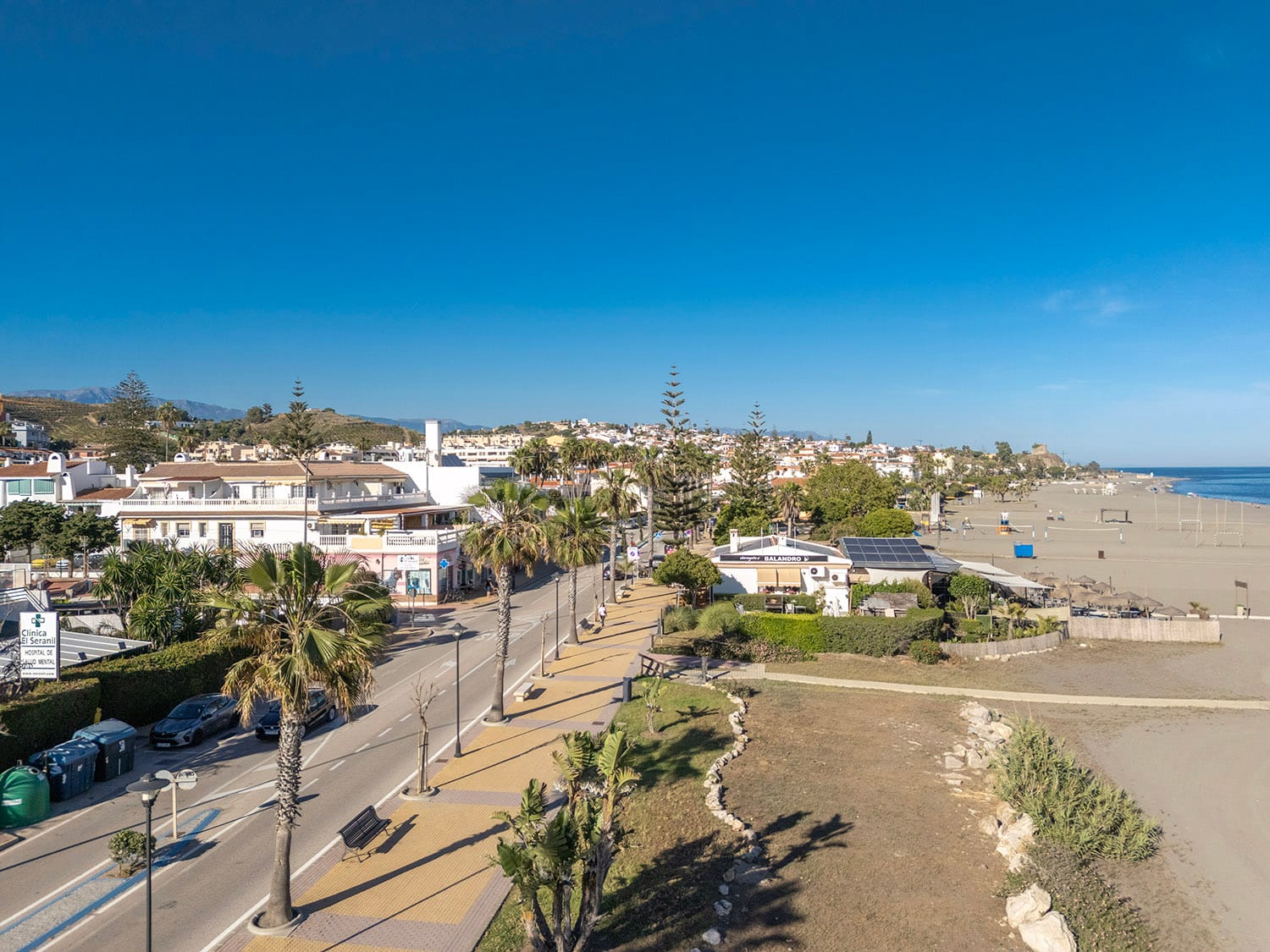 Looking east along the seafront of Benajarafe, showing the coastal main road on the left and the wide expanse of sand on the right. Photo by Jason Elliott for the eastofmalaga.com website.