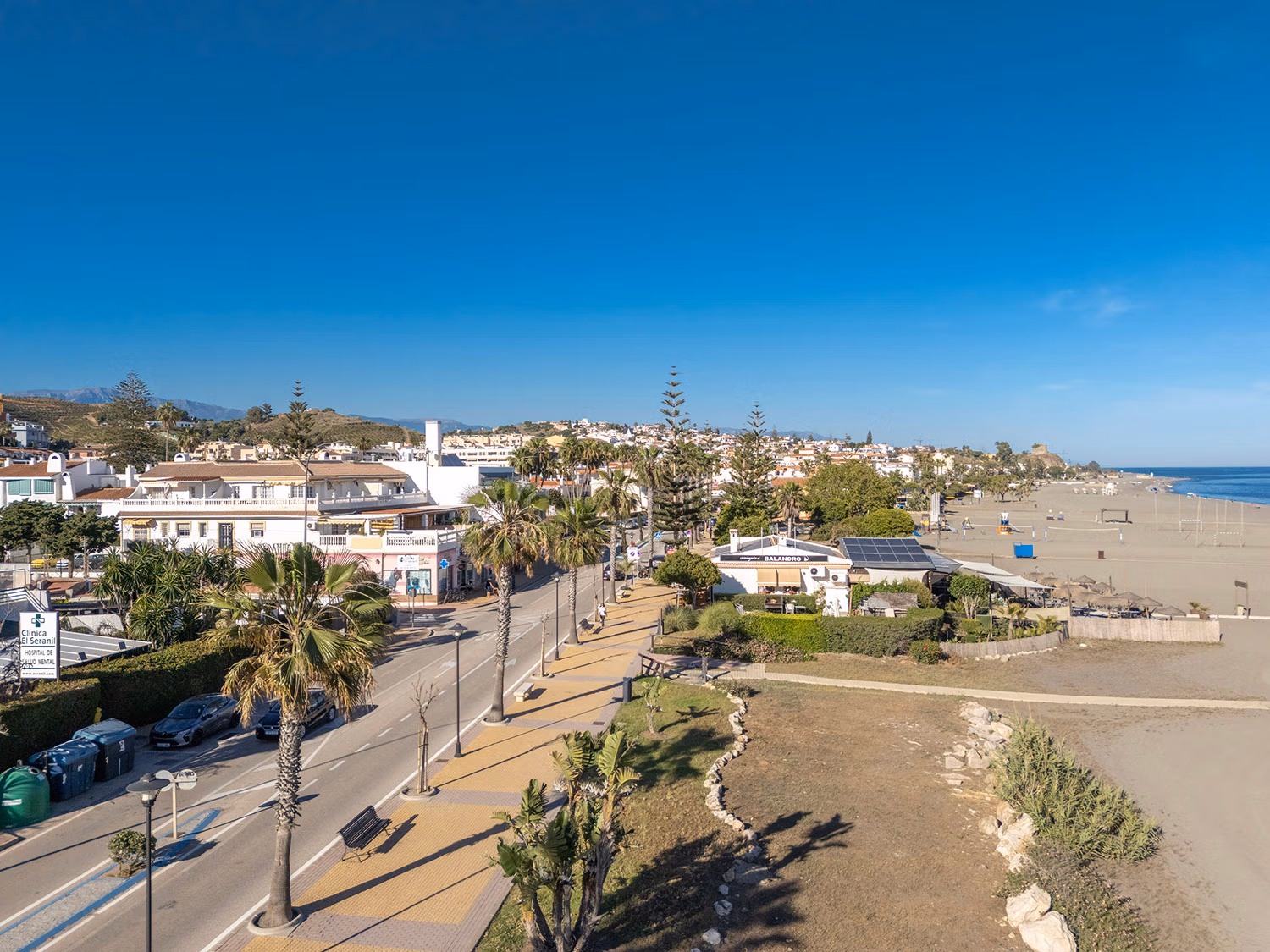 Looking east along the seafront of Benajarafe, showing the coastal main road on the left and the wide expanse of sand on the right. Photo by Jason Elliott for the eastofmalaga.com website.